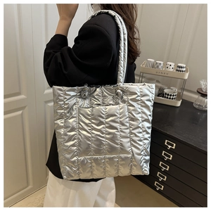 Silver quilted tote bag with metallic finish showing side view on female model