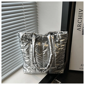 Close-up of metallic silver quilted tote bag with puffer texture and soft sheen