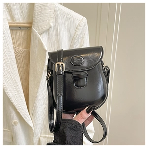 Dettaglio della mini borsa in pelle cerata nera con fibbia in metallo dorato