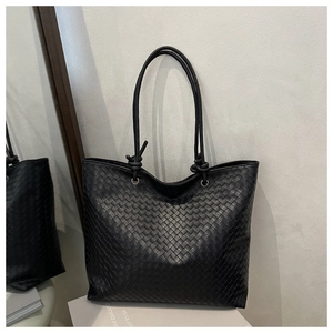 Close-up of the black woven leather tote bag featuring detailed diamond weave patterns