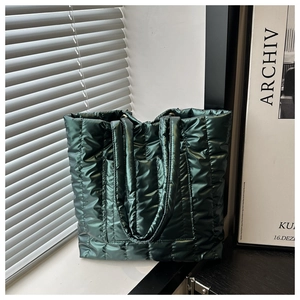 Detail of green quilted puffer tote bag with glossy finish and soft cloud-like texture