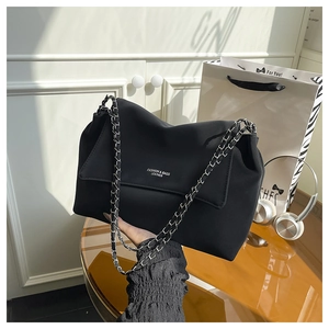 Gros plan du sac en cuir noir avec bandoulière chaîne argentée et logo mode imprimé