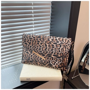 Détail de la pochette léopard avec barre dorée et bandoulière amovible élégante