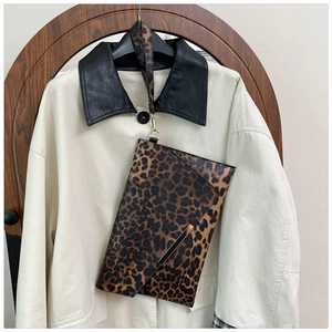 Détail de pochette enveloppe léopard avec bordure dorée et dragonne amovible