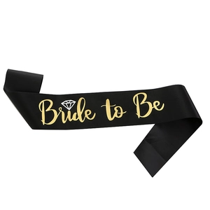 Detail of black satin Bride to Be sash with golden foil lettering and ring icon