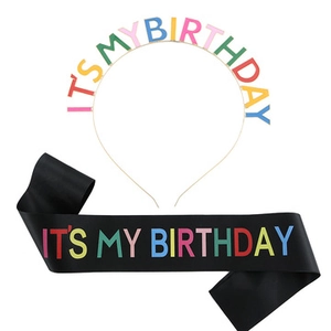 Dettaglio cerchietto dorato e fascia in raso nero con testo colorato It's My Birthday