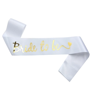 Détail de l'écharpe Bride To Be en satin blanc avec lettrage doré élégant pour fête