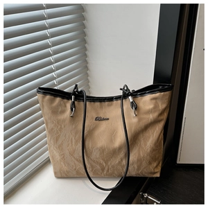 Detailed close-up of khaki tote bag with Balma logo and textured nylon fabric on windowsill