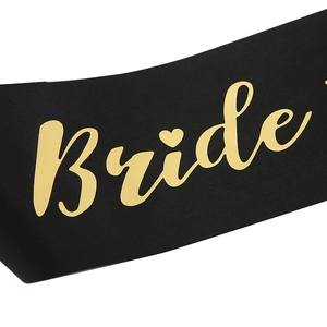 Detail of black satin bachelorette sash with gold foil Bride text and heart icon