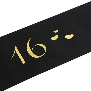 Detail of black satin Sweet 16 sash with gold foil printed number and heart patterns