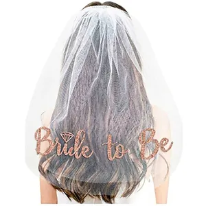 Detail of Bride to Be rose gold glitter lettering on white sheer tulle wedding veil