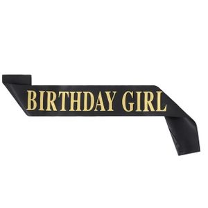 Detail of a black satin Birthday Girl sash with elegant gold foil lettering for parties