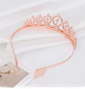 Close-up of rose gold birthday crown with sparkling rhinestones on white satin fabric