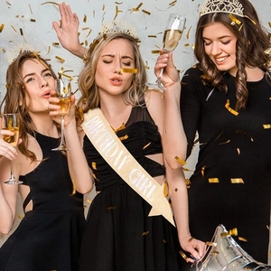Trois femmes fêtant un anniversaire avec des écharpes Birthday Girl et diadèmes or rose