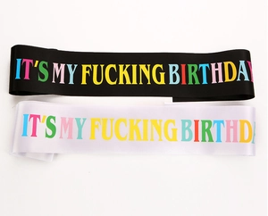 Detail view of black and white satin birthday sashes with colorful gradient text prints