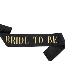 Détail de l'écharpe en satin noir avec lettrage doré Bride to be pour fête de mariage