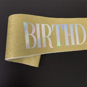 Détail d'une écharpe d'anniversaire dorée avec inscription BIRTHDAY holographique brillante