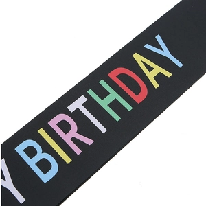 Close-up of black satin sash with colorful Happy Birthday lettering for party decoration