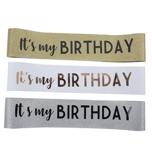 Close-up of glitter fabric sashes in gold, silver, and white with It's my BIRTHDAY text