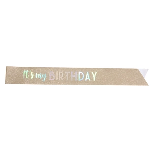 Close-up of champagne gold glitter sash featuring iridescent It's my BIRTHDAY lettering
