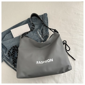 Detail der grauen Umhängetasche mit weißem FASHION-Aufdruck und Webseil-Akzenten