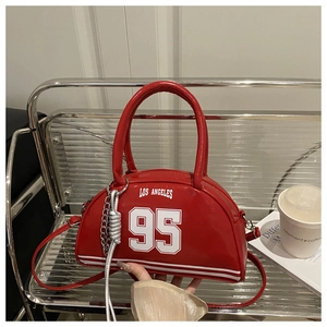Detail of red crescent bag with white number print and stylish metallic chain accessory