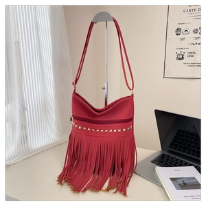 Dettaglio borsa hobo rossa vintage con rivetti dorati e lunghe frange bohémien