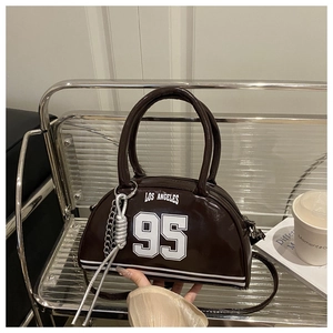 Macro detail of brown leather bag with white LOS ANGELES print and metallic chain ornament