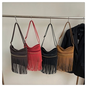 Detailed row of Bohemian fringe crossbody bags in four colors with gold metal studs