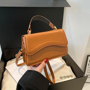 Sac à main marron avec rabat vague en cuir et bandoulière en métal doré chic et élégant