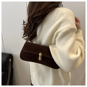 Gros plan d'un sac baguette en daim marron avec boucle en métal doré pour la mode d'automne