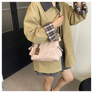 Detail view of pink marble texture bag with dark brown leather strap and fashion tag