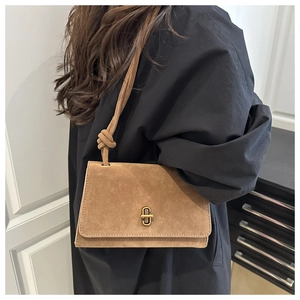 Detail of a brown suede shoulder bag with a vintage gold metal twist lock closure