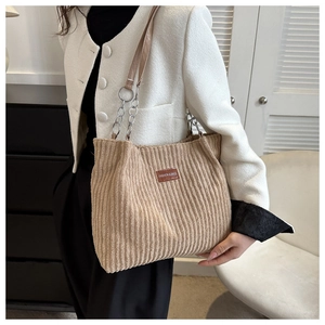 Detail of khaki corduroy shoulder bag with leather chain strap and fashion label