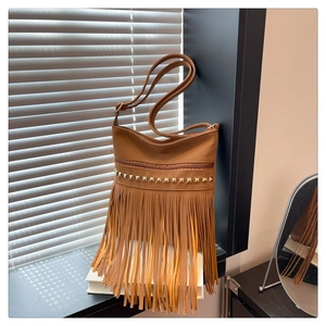Détail du sac bandoulière marron à franges avec clous dorés et longues pampilles