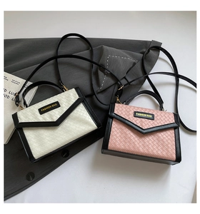 Top view of two contrasting woven crossbody bags with elegant V-shaped trim and top handles