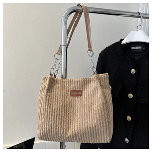 Detail of beige corduroy tote bag showing soft ribbed texture and faux leather strap