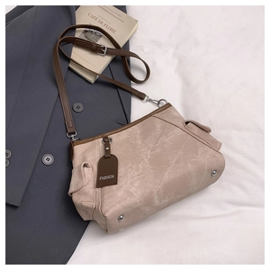 Detail of khaki frosted crossbody bag with side flap pocket and brown adjustable strap