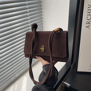 Minimalist dark brown suede evening handbag with unique thick rope handle and gold lock