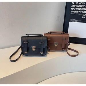 Detail view of vintage leather handbags in black and brown with metal buckles and strap