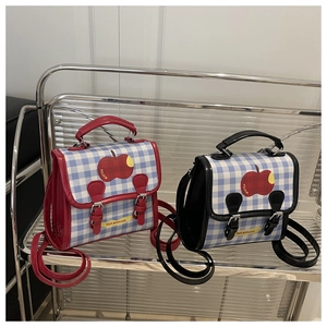 Detail of red and black checkered children backpacks with apple embroidery on display