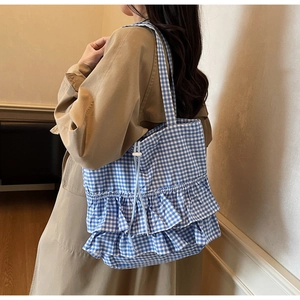 Detail of blue and white checkered tote bag with tiered ruffles and drawstring closure