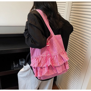 Close-up of pink checkered tote bag with ruffled edges and decorative drawstring