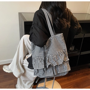 Detail of black and white vichy check tote bag featuring elegant double layer ruffled edges