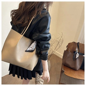 Detail of pleated tote bag featuring marble print ribbon and beige faux leather texture