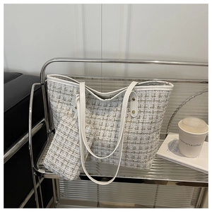 Close-up of white tweed tote bag with gold thread and small matching accessory pouch