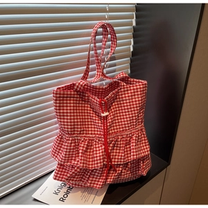 Detail of red gingham tote bag featuring double-layered ruffle trim and drawstring closure
