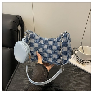 Détail du sac bandoulière en denim à damier bleu avec bords effilochés et chaîne argent