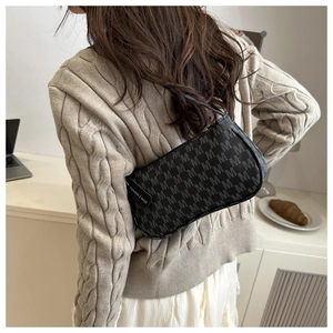 Detailed view of black leather crossbody bag with M-monogram and fashion tag