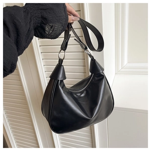 Detail view of black matte PU leather hobo bag featuring silver ring hardware and shoulder strap